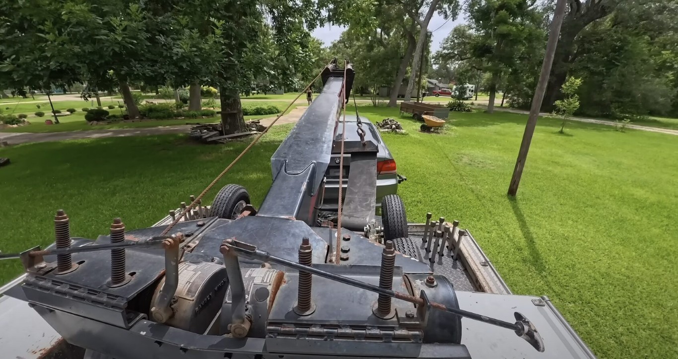 Heavy duty tow truck with extended boom arm performing a winch recovery operation